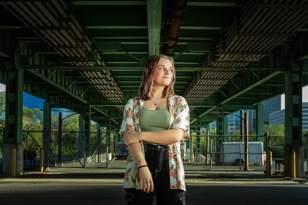 High school senior girl standing under an overpass in the Crossroads District, captured by the best Kansas City senior photographer during an urban portrait session.